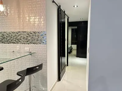 a bathroom with a walk in shower and a glass door at Apartamento familiar en el Poblado Medellín in Medellín