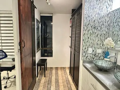 a bathroom with a sink and a counter with a desk at Apartamento familiar en el Poblado Medellín in Medellín