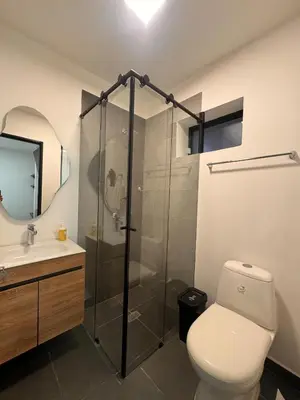 a bathroom with a toilet and a glass shower at Apartaestudios Zeni in Medellín