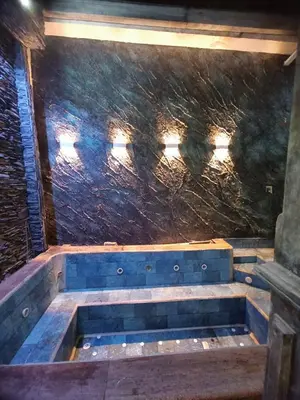 a bathtub in a room with a stone wall at Casa Epoca Dorada in Medellín