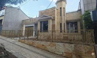 an old stone house with a fence on a street at Casa Epoca Dorada in Medellín