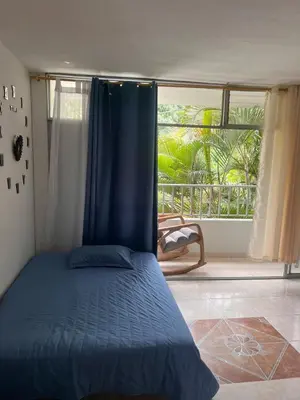 a bedroom with a bed and a large window at Apartamento Buenos Aires in Medellín