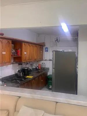 a kitchen with wooden cabinets and a stainless steel refrigerator at Apartamento Buenos Aires in Medellín
