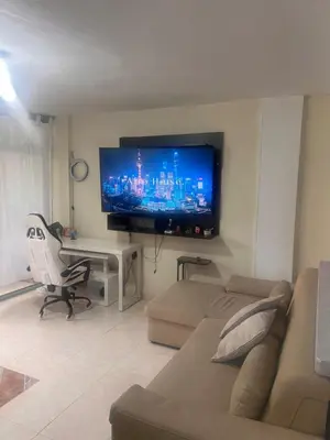 a living room with a couch and a flat screen tv at Apartamento Buenos Aires in Medellín
