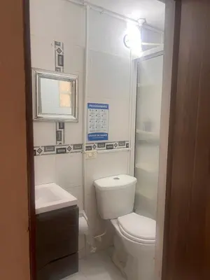 a white bathroom with a toilet and a sink at Apartamento Buenos Aires in Medellín