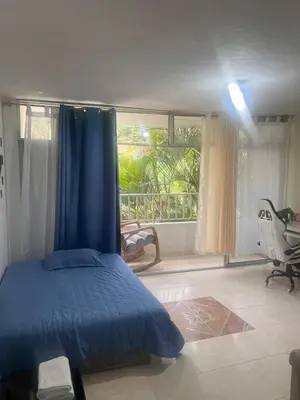 a bedroom with a blue bed and a window at Apartamento Buenos Aires in Medellín