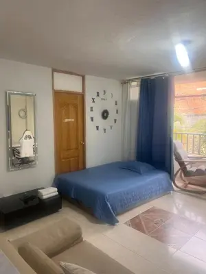 a bedroom with a blue bed and a chair at Apartamento Buenos Aires in Medellín