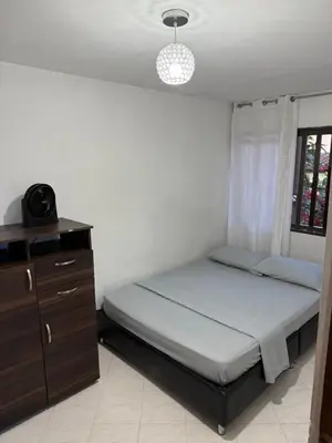 a bedroom with a bed and a dresser and a window at Apartamento céntrico y acogedor in Medellín