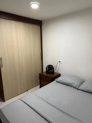 a bedroom with a bed and a telephone next to a door at Apartamento céntrico y acogedor in Medellín