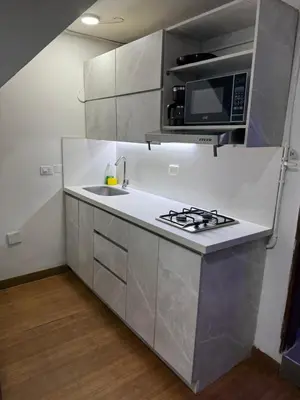 a kitchen with a stove and a microwave at Apartamento céntrico y acogedor in Medellín