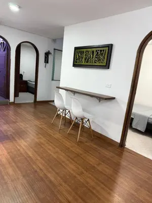 a room with a white piano and two chairs at Apartamento céntrico y acogedor in Medellín