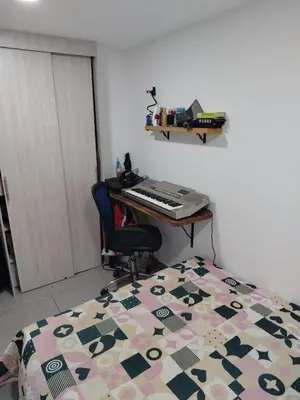 a bedroom with a bed and a desk with a keyboard at Habitación en Medellín in Medellín