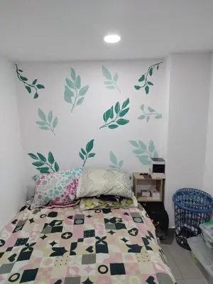 a bedroom with a bed with green leaves on the wall at Habitación en Medellín in Medellín