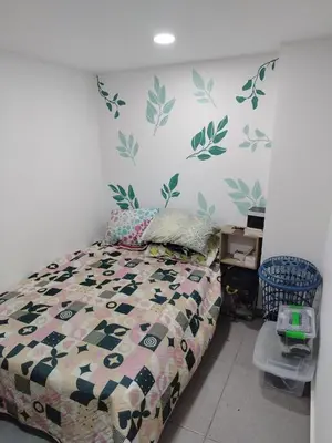 a bedroom with a bed with leaves on the wall at Habitación en Medellín in Medellín
