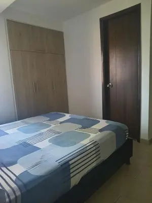 a bedroom with a bed and a wooden cabinet at Habitación en conjunto in Medellín