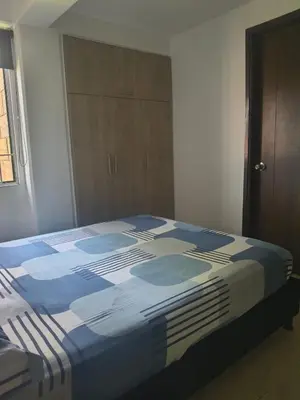 a blue and white bed in a room at Habitación en conjunto in Medellín