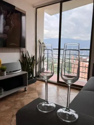 two wine glasses sitting on a table in front of a window at Beautiful 29th floor apartment with a view in Medellín