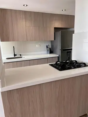 a kitchen with wooden cabinets and a stove top oven at Beautiful 29th floor apartment with a view in Medellín