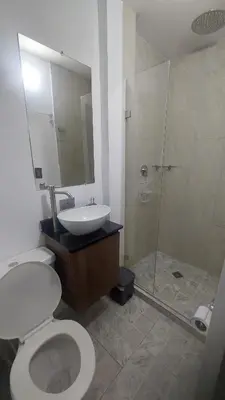a bathroom with a toilet and a sink and a shower at Laureles Estadio Lofts 33 in Medellín