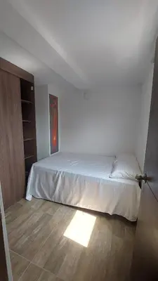 a bedroom with a bed and a wooden floor at Laureles Estadio Lofts 33 in Medellín