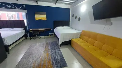a hotel room with two beds and a couch at Laureles Estadio Lofts 33 in Medellín