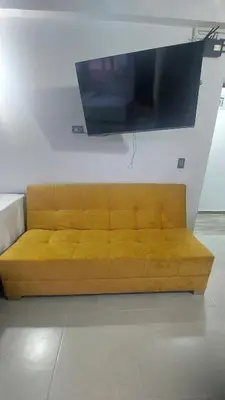 a brown couch with a flat screen tv on a wall at Laureles Estadio Lofts 33 in Medellín