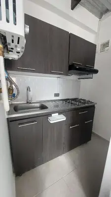 a kitchen with brown cabinets and a sink at Laureles Estadio Lofts 33 in Medellín