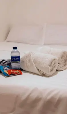 a bottle of water and a blanket on a bed at hotel chanel in Itagüí