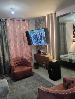 a living room with a tv and a chair and a bed at Apto medellin in Medellín
