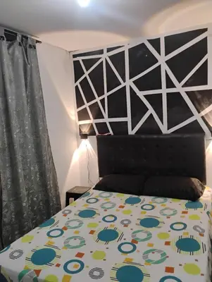 a bedroom with a bed with a black and white bedspread at Apto medellin in Medellín