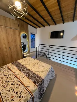 a bedroom with a bed and a flat screen tv at Apartamento nuevo, moderno y acogedor in Itagüí