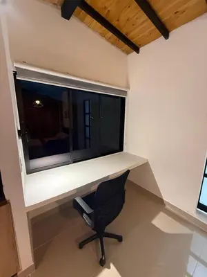 a desk with a chair in front of a window at Apartamento nuevo, moderno y acogedor in Itagüí