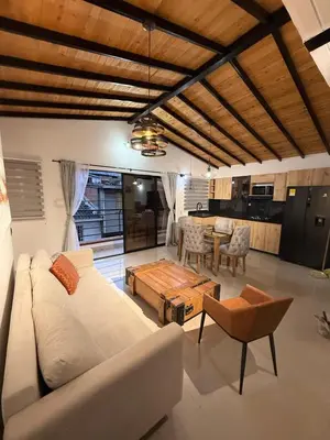 a living room with a white couch and a table at Apartamento nuevo, moderno y acogedor in Itagüí