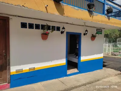 a blue and white building with a bed in it at YoAmoJardín, Parejas, es como estar en casa in Jardin