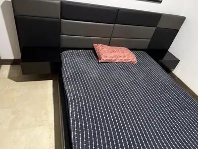 a bed with a black headboard and a pink pillow at Apartamento Deluxe poblado in Medellín