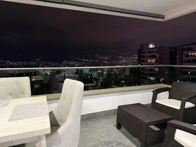 a dining room with a view of a city skyline at Apartamento Deluxe poblado in Medellín