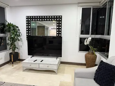 a living room with a tv and a coffee table at Apartamento Deluxe poblado in Medellín