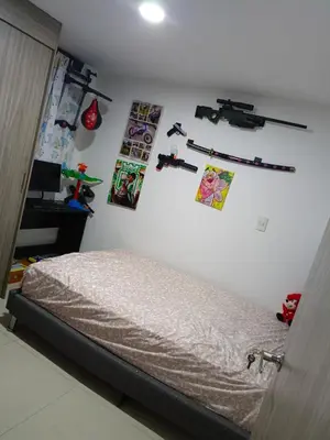 a bedroom with a bed and some pictures on the wall at Edificio sefi in Medellín
