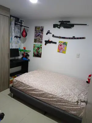 a bedroom with a bed and some pictures on the wall at Edificio sefi in Medellín