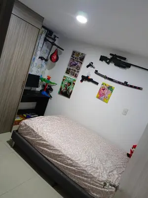 a bedroom with a bed and some pictures on the wall at Edificio sefi in Medellín