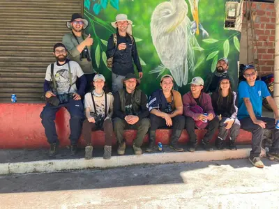 a group of people posing for a picture in front of a mural at Selvática Ecohotel y Centro Holístico in San Carlos