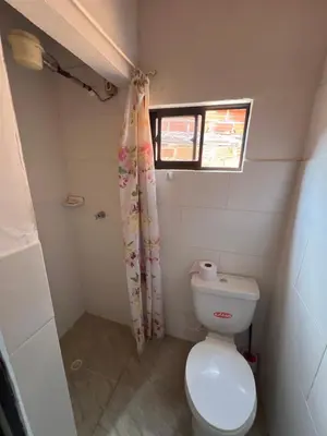 a small bathroom with a toilet and a window at Home river in Itagüí