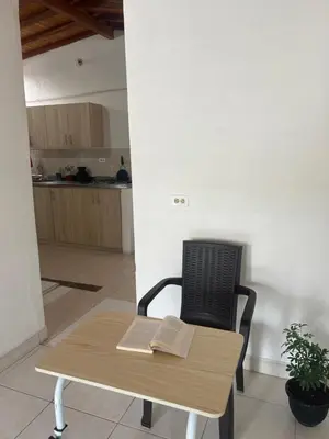 a table and a chair with a book on it at Home river in Itagüí