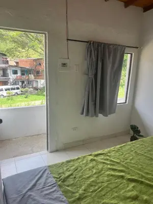 a bedroom with a bed and a large window at Home river in Itagüí