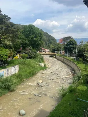 a river with a bridge in the background at Home river in Itagüí