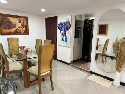 a dining room with a table and chairs and a mirror at Pilar house in Medellín
