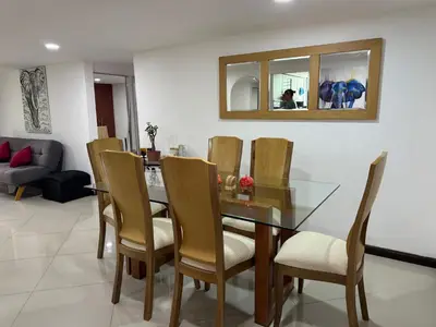 a dining room with a glass table and chairs at Pilar house in Medellín