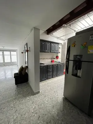 a kitchen with a refrigerator in the middle of a room at Tu rincón en Medellín in Medellín