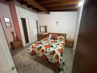 a bedroom with a bed with a floral comforter at Tu rincón en Medellín in Medellín