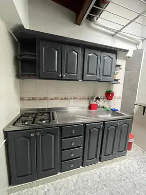 a kitchen with black cabinets and a stove at Tu rincón en Medellín in Medellín